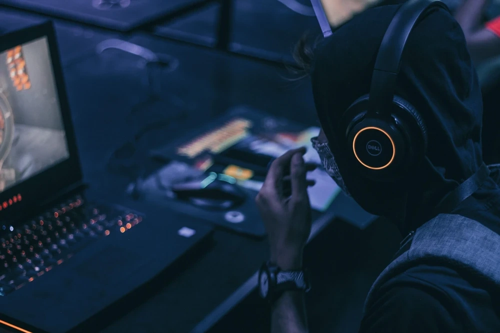 Gamer sitting in front of gaming laptop playing games