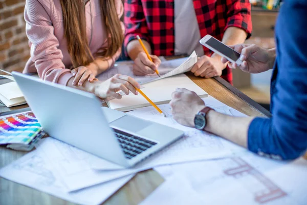 Team standing around a working desk